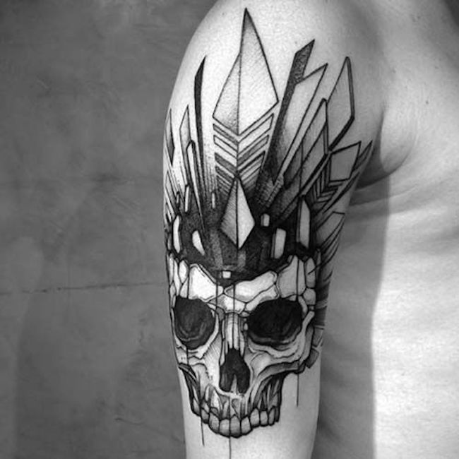 a man's arm with a skull tattoo on it and an arrow in the middle