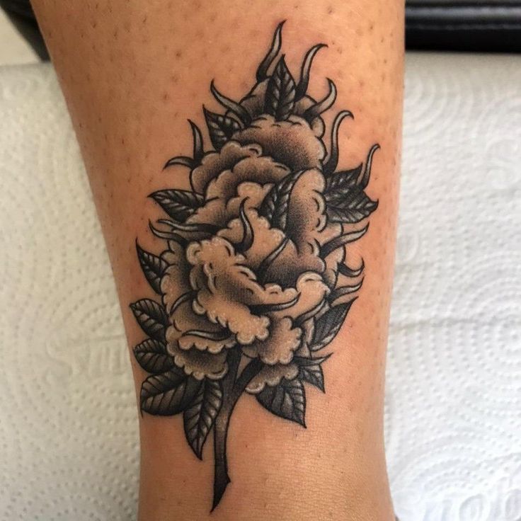 a woman's leg with a flower tattoo on it