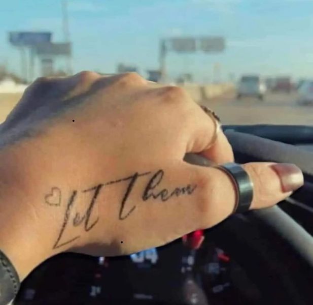 a person with a tattoo on their arm driving a car