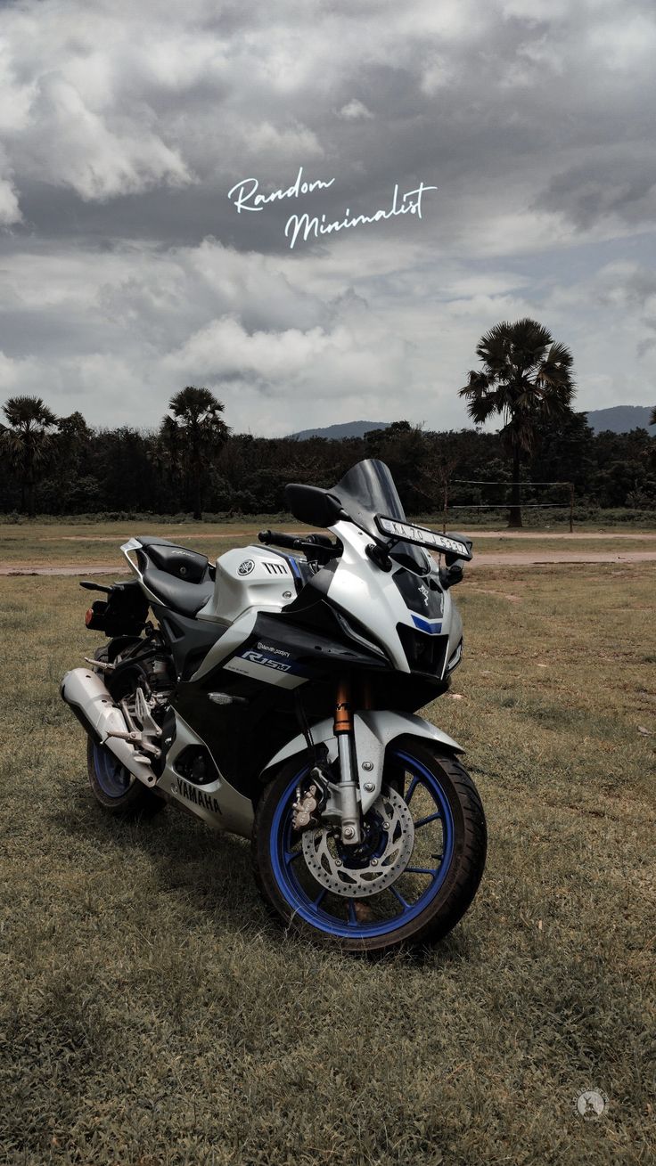 a motorcycle parked in the grass on a cloudy day