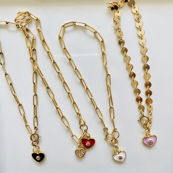 Loving these new heart charm bracelets. Something about them reminds me of the playfulness of childhood, but with an updated elegant (and adult) twist. These enamel charms are available in red, light pink, white, and black, and are all accented with a cubic zirconia. Charm also available in a cubic zirconia heart. If you like the looks of how some are styled in the pictures with multiple charms, please contact me for a customizable bracelet. Otherwise, each bracelet comes with 1 charm. Charms ar Heart-shaped Charm Necklaces With Removable Charms, White Heart-shaped Metal Charm Bracelet, Trendy Heart-shaped Bracelet For Gift, Pink Everyday Heart Bracelet, Everyday Pink Heart Bracelet, Trendy Heart Charm Bracelet As Gift, Red Heart Charm Jewelry For Friendship, Trendy Heart Charm Bracelet For Gift, Trendy Heart Charm Bracelet Gift