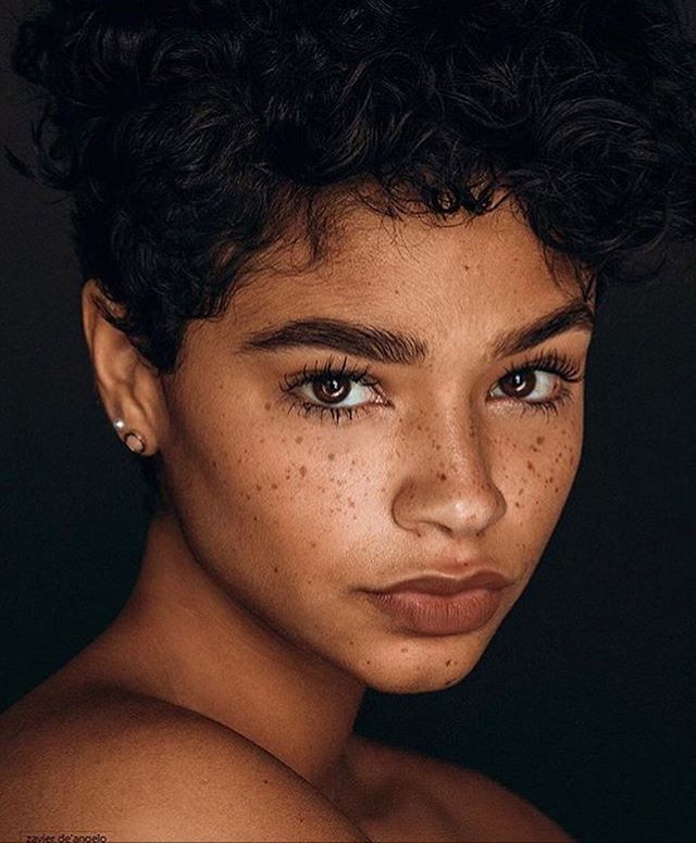 a woman with freckles on her face and chest is looking at the camera