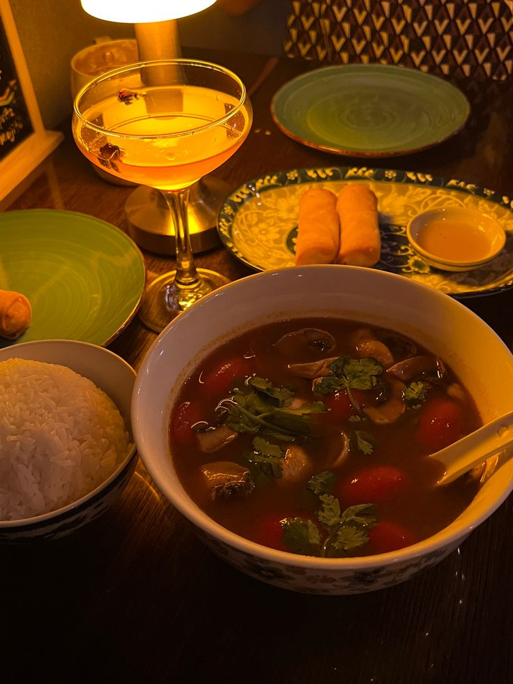 a table topped with bowls and plates filled with food