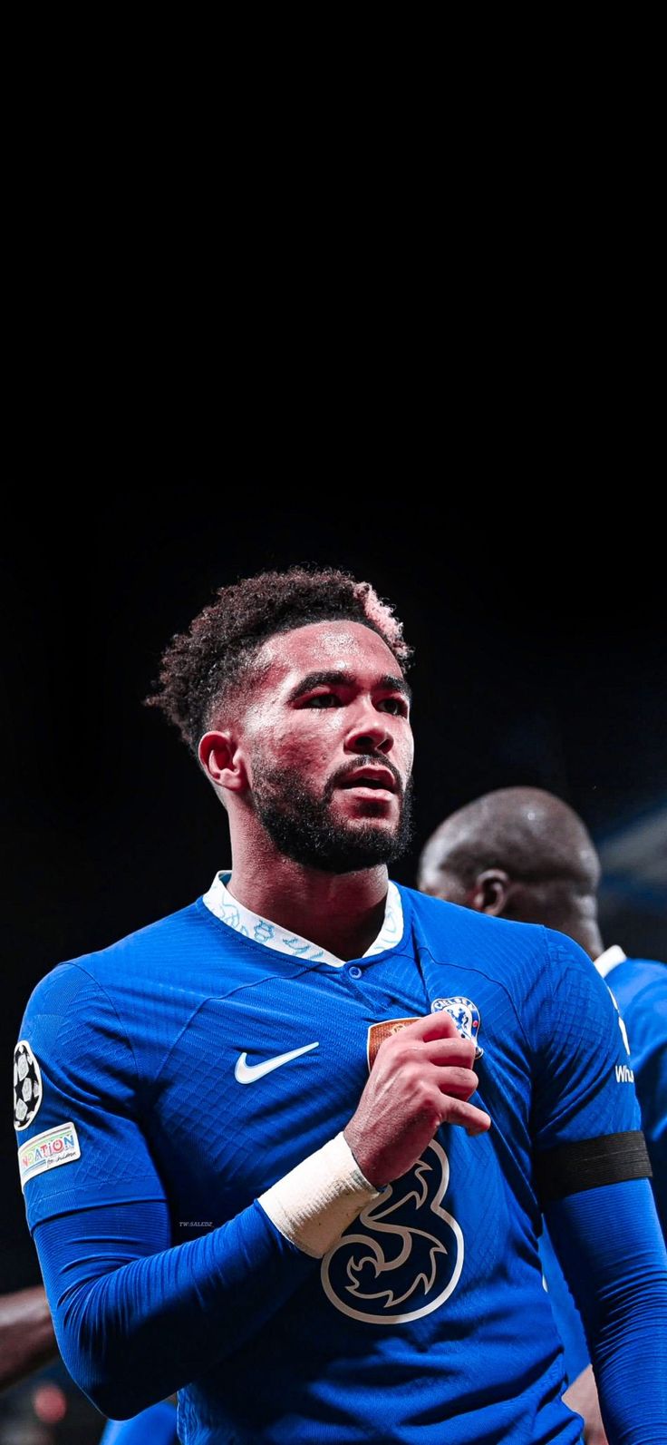 two soccer players in blue uniforms standing next to each other