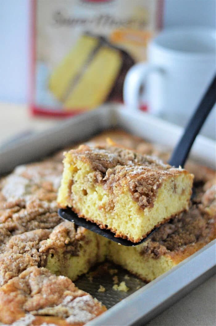 a close up of a tray of food with some cake on it and a cup in the background