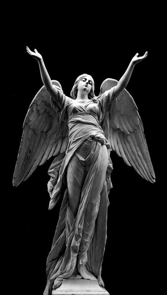 an angel statue with its arms spread out in front of a black background, it looks like he is holding his hands up to the sky