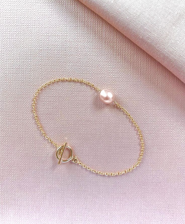 The name Amara comes from the root word Amar, meaning to love, and in other languages it means "to make a home." Featuring a lustrous pink pearl, Amara Pearl Bracelet is balanced by our signature clasp detail which allows you to put on quickly and easily. Amara Pearl Bracelet is made of genuine freshwater pearl and 14k gold fill chain. Bracelet is custom made for you by hand in New York, please allow 2-3 weeks shipping. Classic Pink Jewelry For Promise, Classic Pink Bracelets, Rose Gold Pearl Bracelets With Pearl Chain, Rose Gold Pearl Bracelet With Pearl Charm, Classic Pink Pearl Chain Jewelry, Rose Gold Bracelet With Pearl Charm As Gift, Rose Gold Bracelet With Pearl Charm For Gift, Elegant Pink Charm Bracelet With Round Beads, Rose Gold Bracelet With Pearl Charm