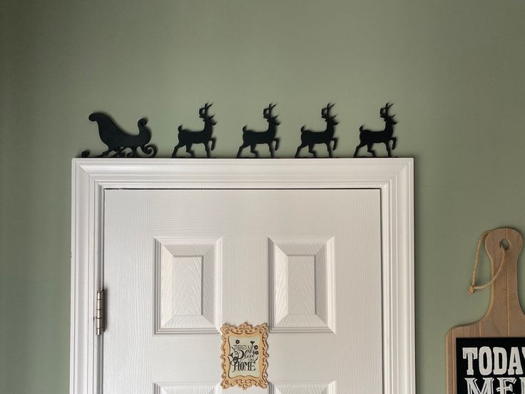 a white door with some black reindeer decorations on it