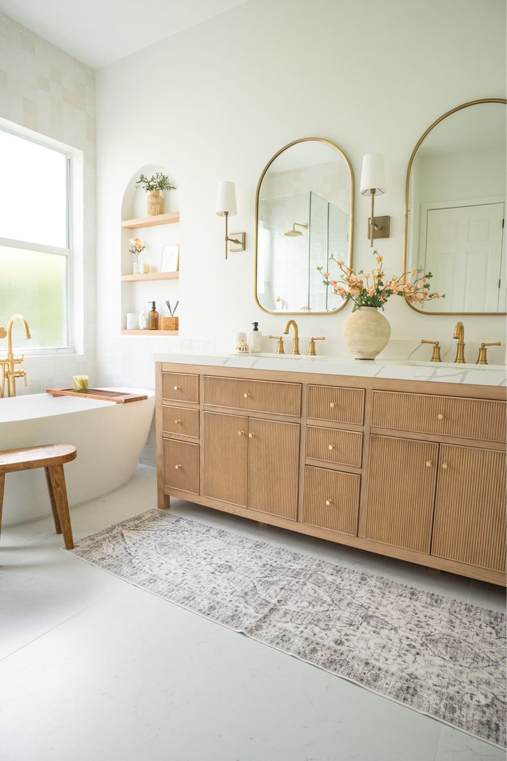 a bathroom with two sinks and a bathtub in the middle, along with a rug on the floor