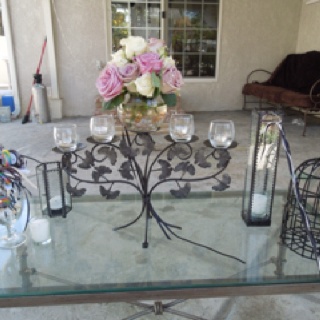 a glass table with flowers and candles on it