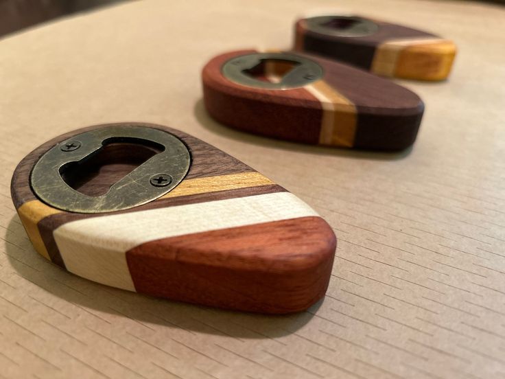 three wood and metal objects sitting on top of a table