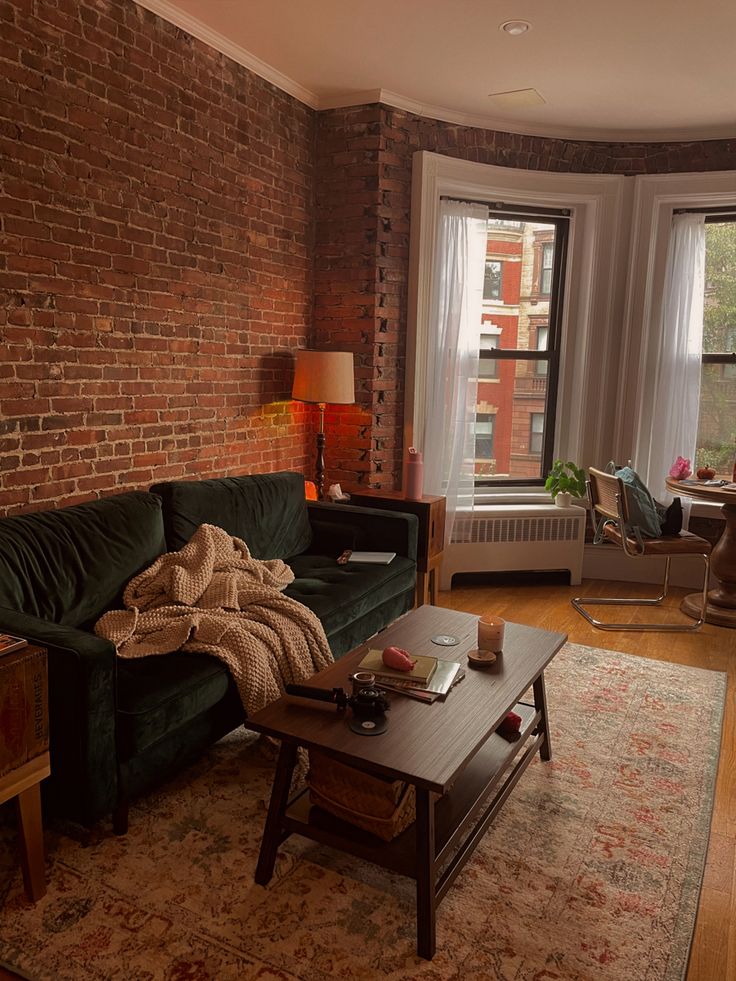 a living room filled with furniture and a brick wall behind the couch is a coffee table