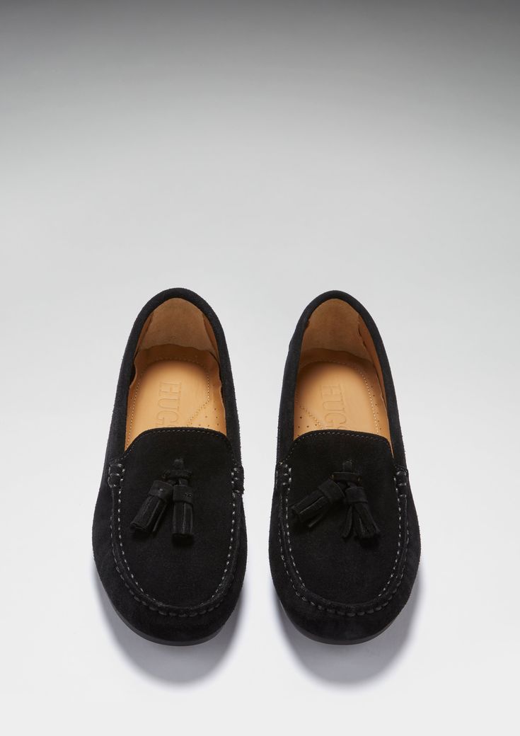 Hugs & Co. tasselled black suede penny loafer driving shoes for women. Moccasin style driving loafers in luxurious black suede outer and lined with a soft leather for extra comfort. The full rubber sole gives this classic loafer a more versatile twist! We recommend taking a size down in this full rubber sole style. Italian Suede Upper Rubber sole Natural Tan Leather Lining Traditional Hand Stitching Lightly Padded Insole Made in Portugal Black Slip-on Tassel Loafers With Rubber Sole, Elegant Black Slip-on Tassel Loafers, Black Leather Footbed Slip-on Tassel Loafers, Timeless Black Slip-on Tassel Loafers, Luxury Black Tassel Slip-on Loafers, Moccasins Style, Driving Loafers, Moccasins Mens, Tassel Loafers