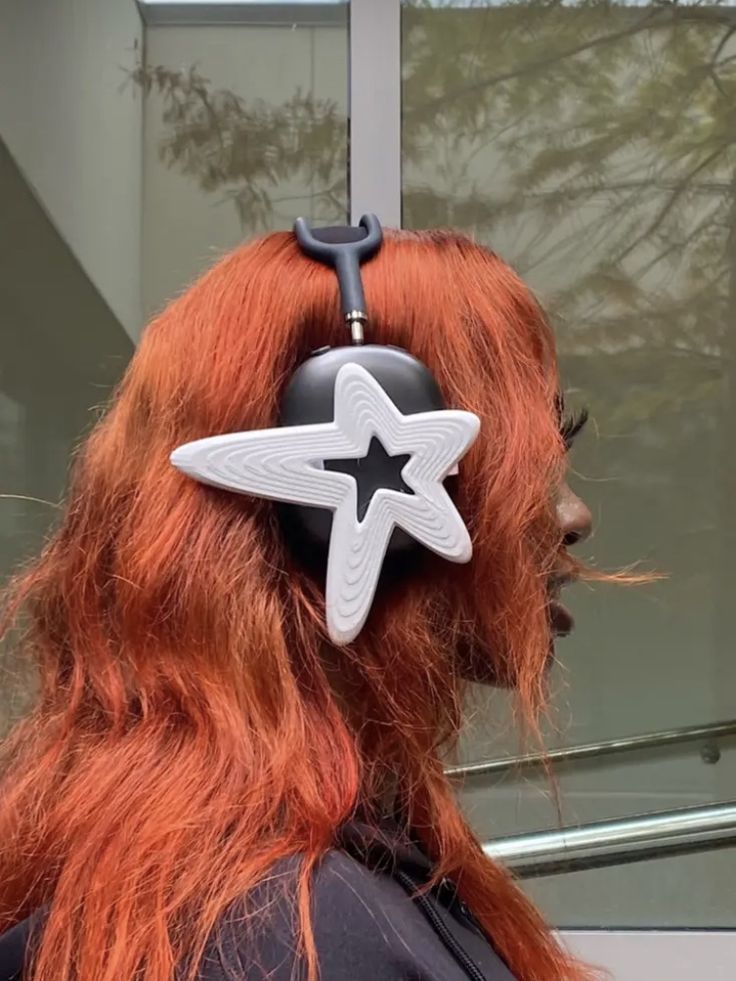 a woman with red hair wearing a pair of scissors on her head