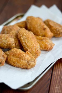 fried chicken nuggets are on a white paper towel next to a fork and spoon