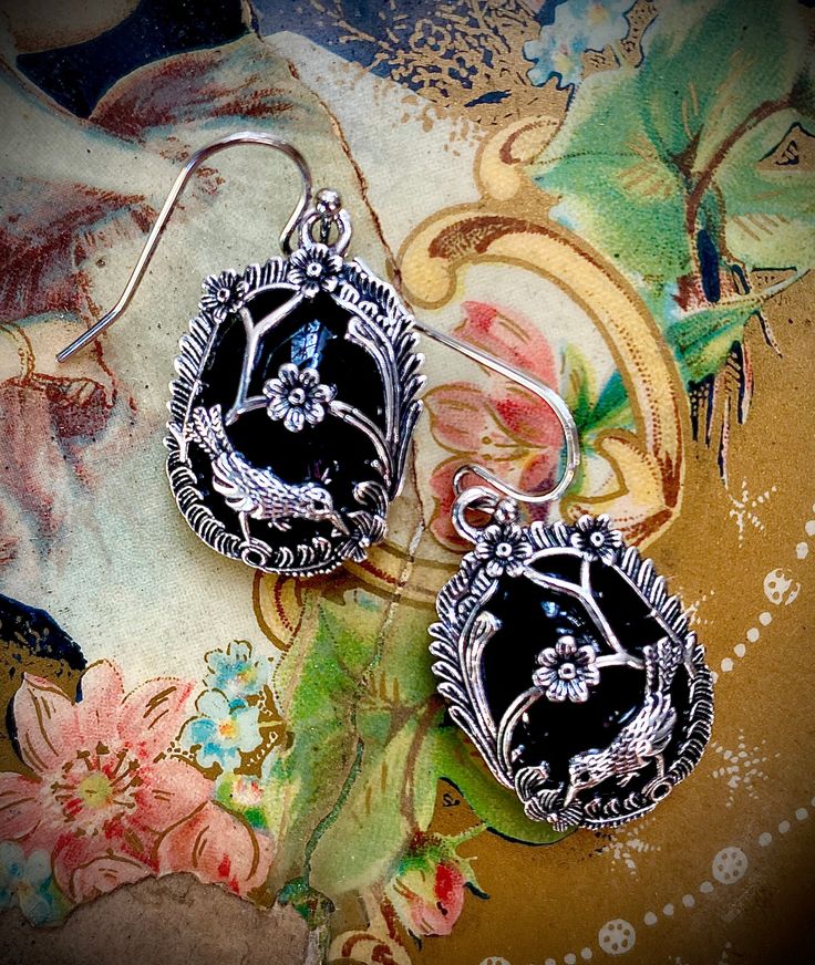 Inspired by the caged velvet perfume buttons from the Civil War era, a silver-plated overlay on faux black jet is the descendant of coveted mourning jewelry borrowed from the jewel box of someone’s great, great grandmother. These feather-light earrings with surgical steel French wires will complement gray and black attire. Both dressy and casual. 1” Oval Black Enamel Jewelry Gift, Black Vintage Oxidized Jewelry, Vintage Oxidized Black Jewelry, Black Oval Vintage Earrings, Vintage Black Oval Earrings, Antique Black Dangle Jewelry, Nickel-free Victorian Metal Jewelry, Ornate Black Sterling Silver Jewelry, Victorian Antique Silver Jewelry