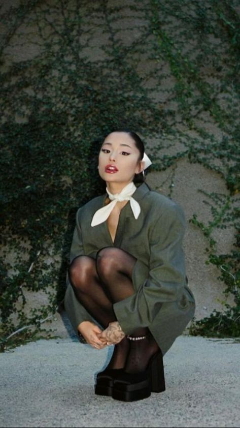 a woman sitting on the ground in tights and stockings with her legs crossed out