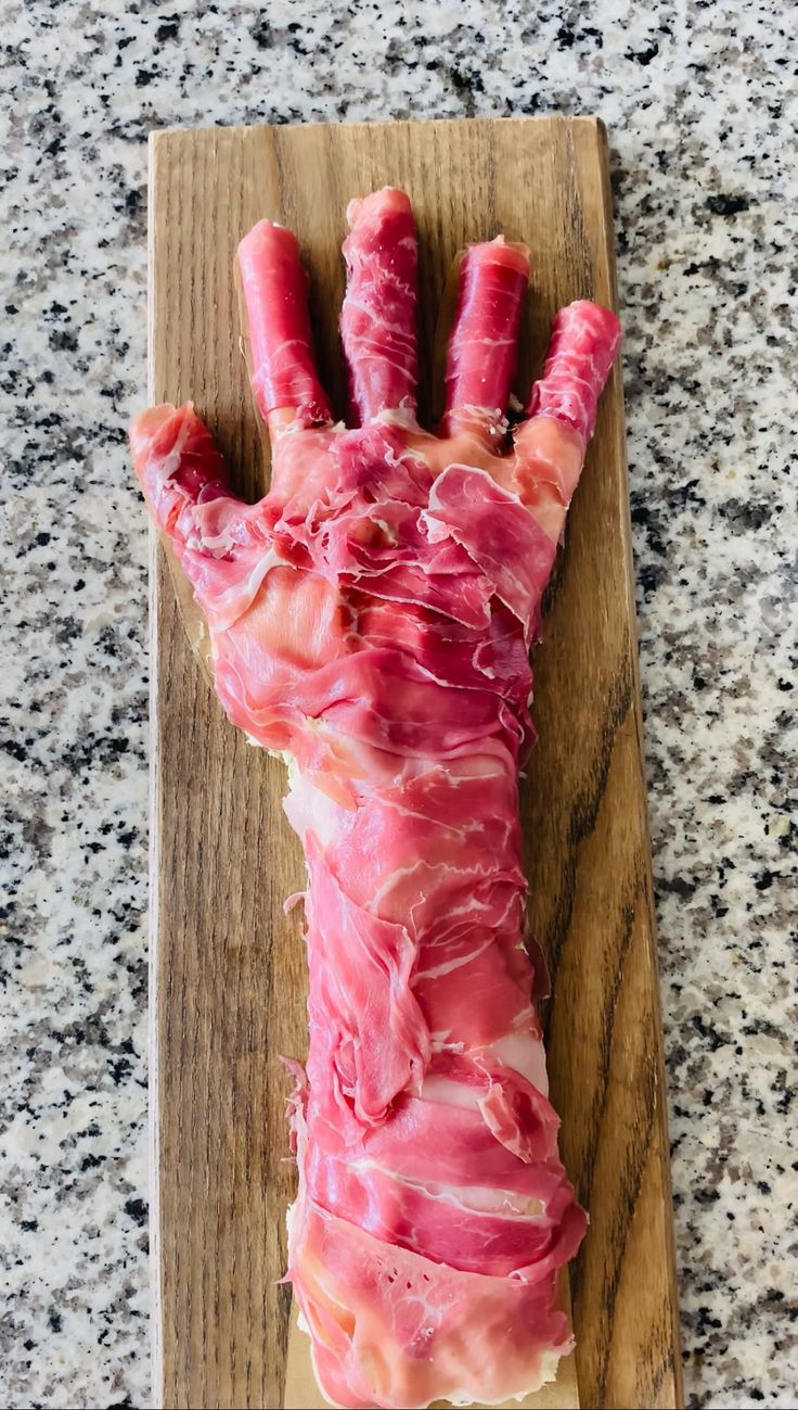 a piece of meat wrapped in bacon on a cutting board