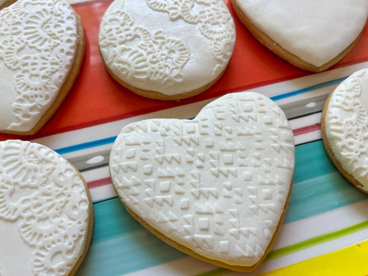 several decorated heart shaped cookies on a plate