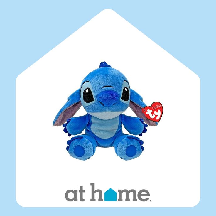 a blue stuffed animal sitting in front of the at home logo