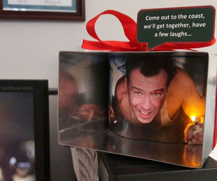 a man holding a lit candle in front of a box with a message on it