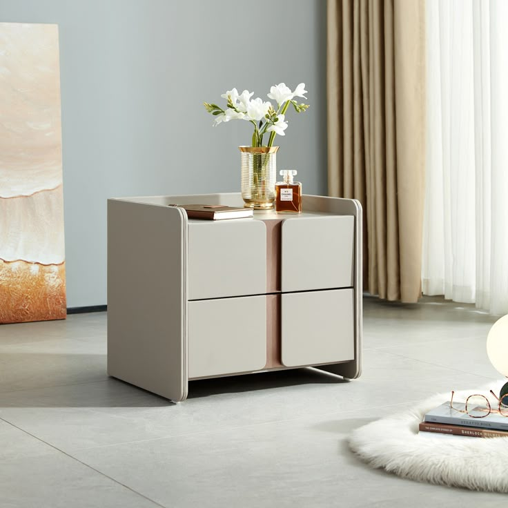 a white table with two drawers and a vase on top