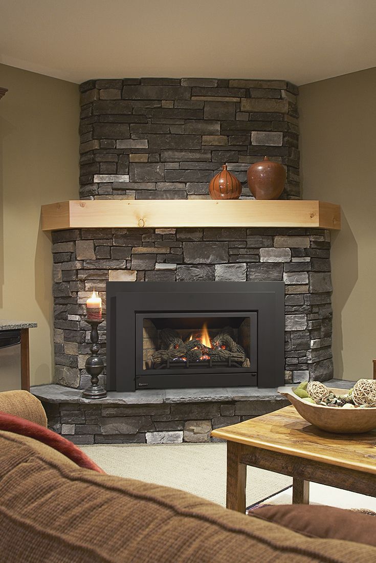 a living room with a fire place in the center and a table on the other side