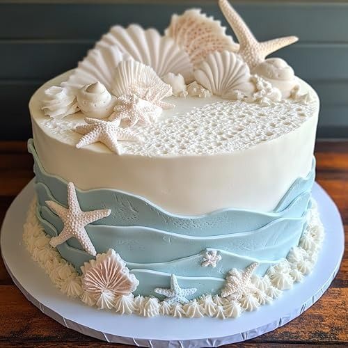 a white and blue cake with sea shells on it