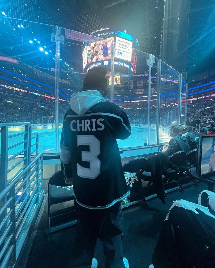 a hockey player standing in front of an ice rink