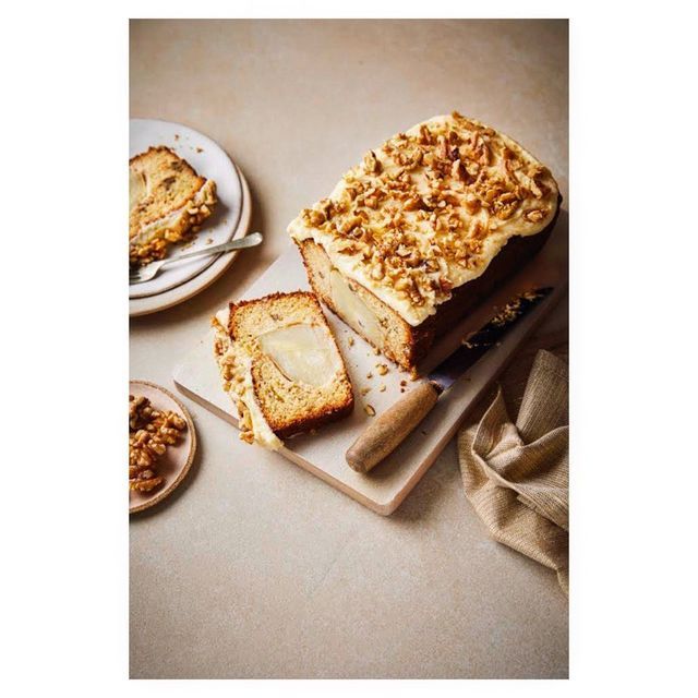 two slices of cake sitting on top of plates next to another piece of cake with walnuts