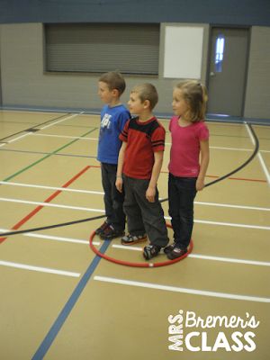 three young children standing on top of a basketball court while looking at something in the distance