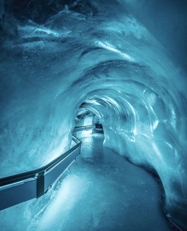 an ice cave with stairs leading to the top and water flowing down it's sides