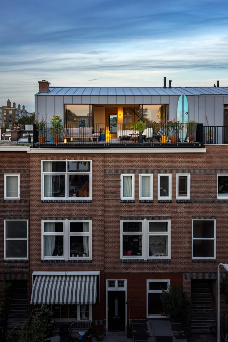 an apartment building with lots of windows and balconies on the top floor is shown