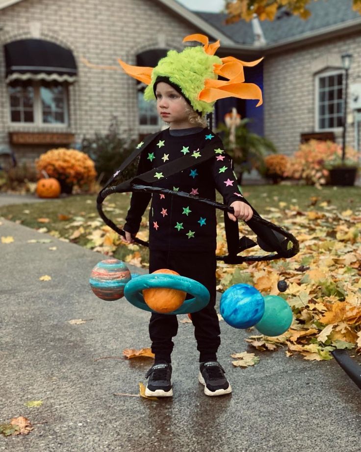 a young boy wearing a costume and holding an object