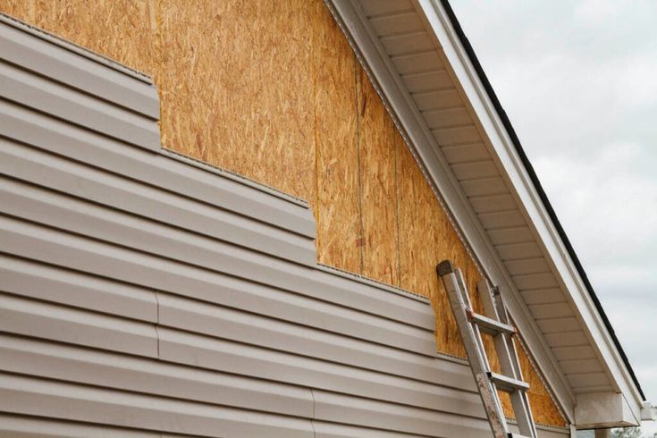 a ladder is leaning against the side of a house that's being boarded up