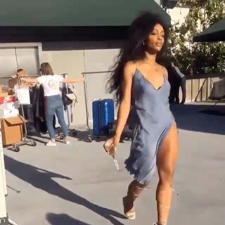 a woman in a blue dress is walking down the street with her legs spread out