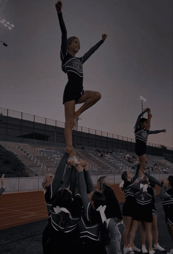 two cheerleaders doing stunts on top of each other