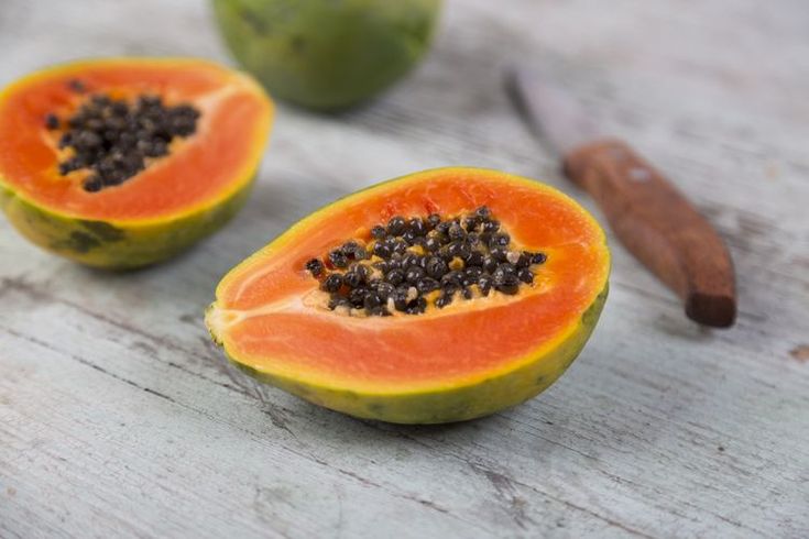 two pieces of papaya sitting on top of a wooden table