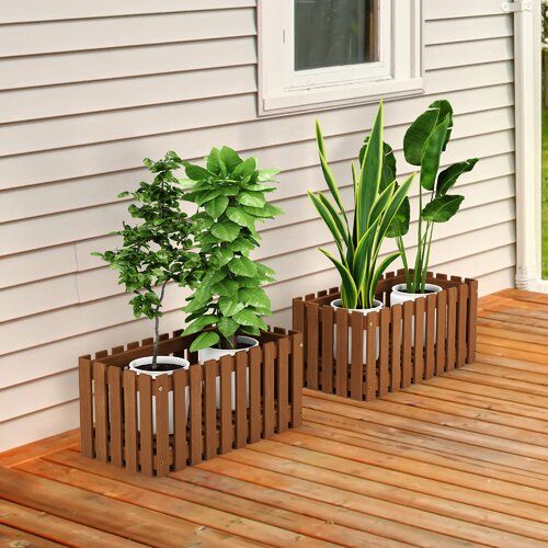 three potted plants sitting on top of a wooden deck