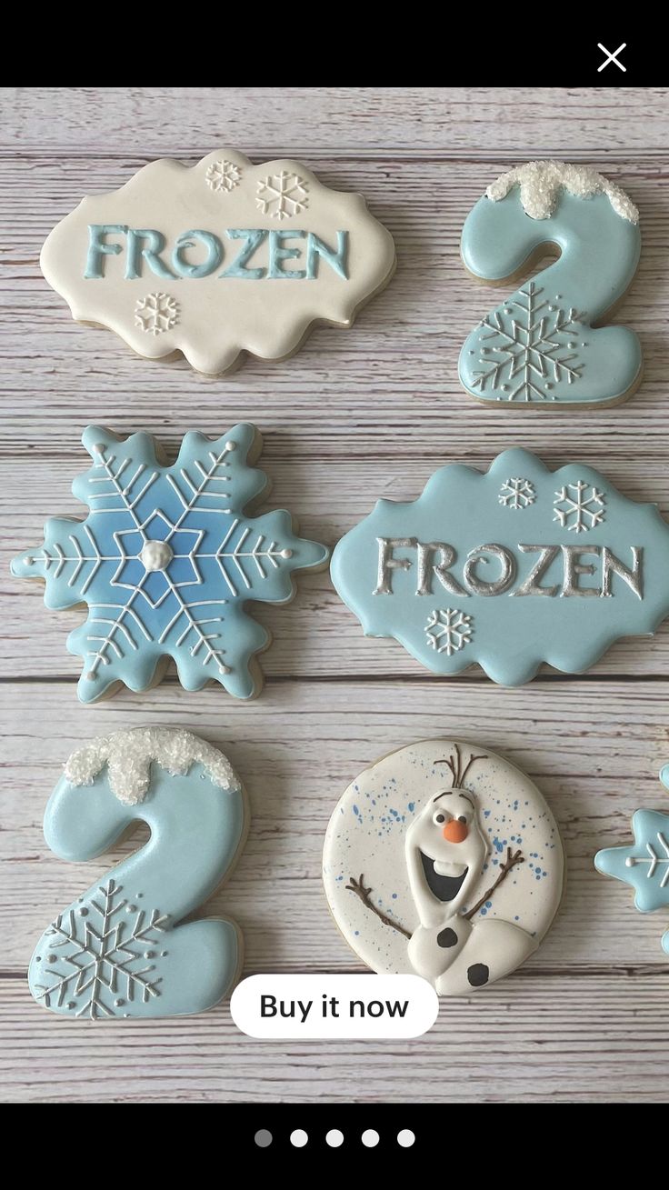 cookies decorated with frosting and icing are displayed on a wooden surface, including the words frozen