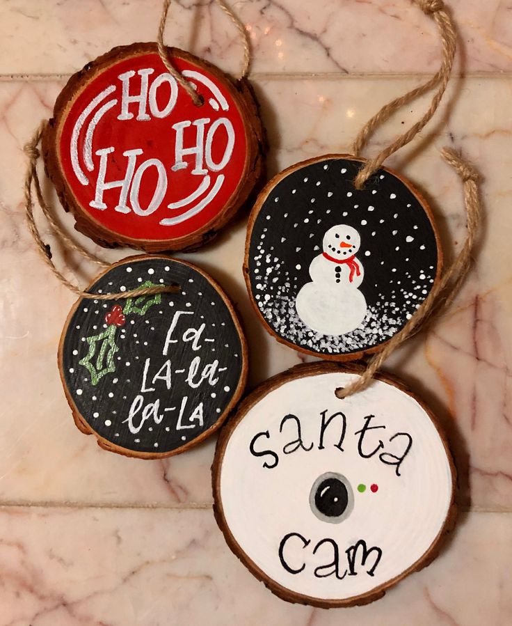 three christmas ornaments are hanging on a marble counter top, with the words santa claus written on them