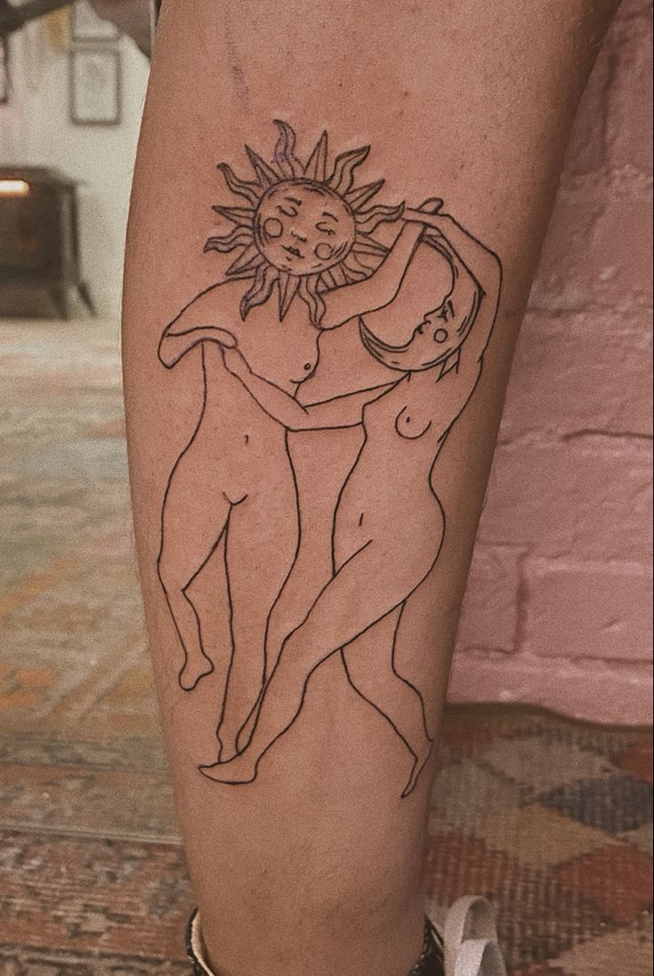 a tattoo on the leg of a person with a sun and moon above her head