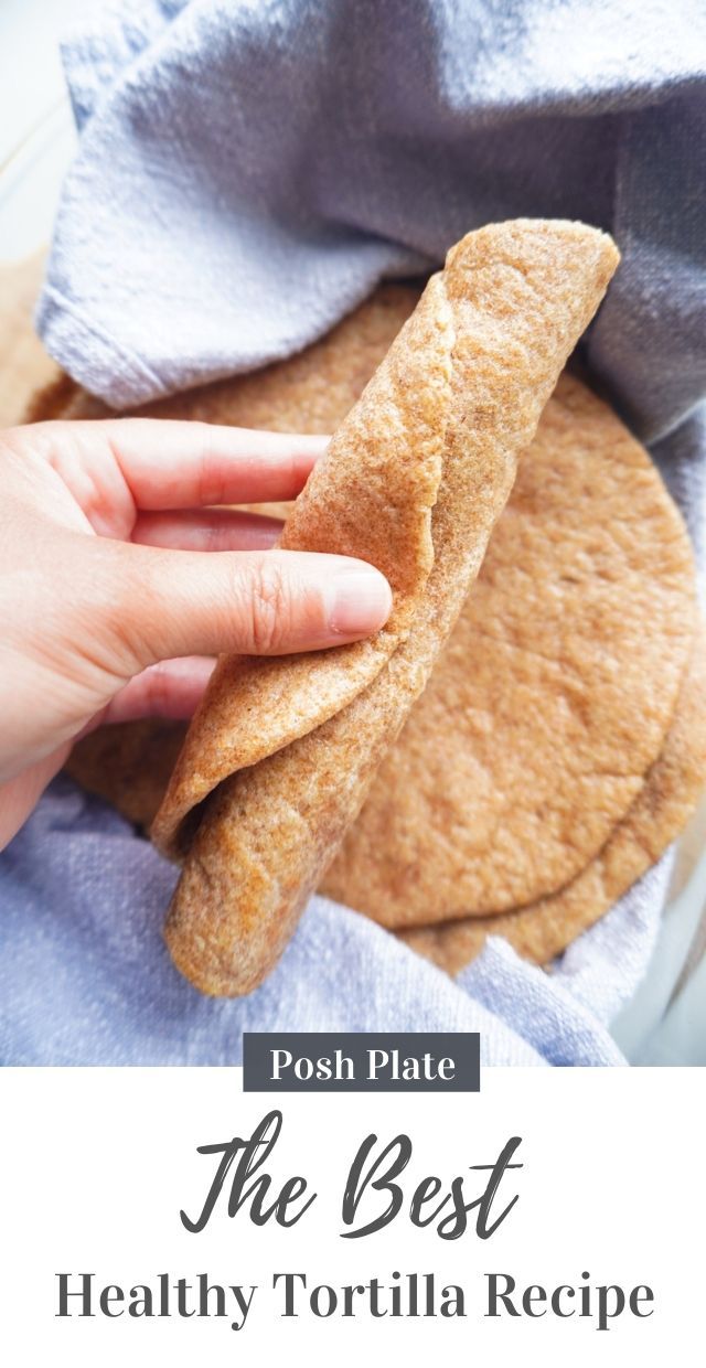 a person holding a piece of bread on top of a blue towel in front of a bowl