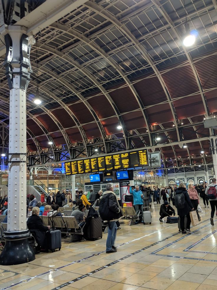 many people are waiting for their luggage at the train station in an empty terminal area