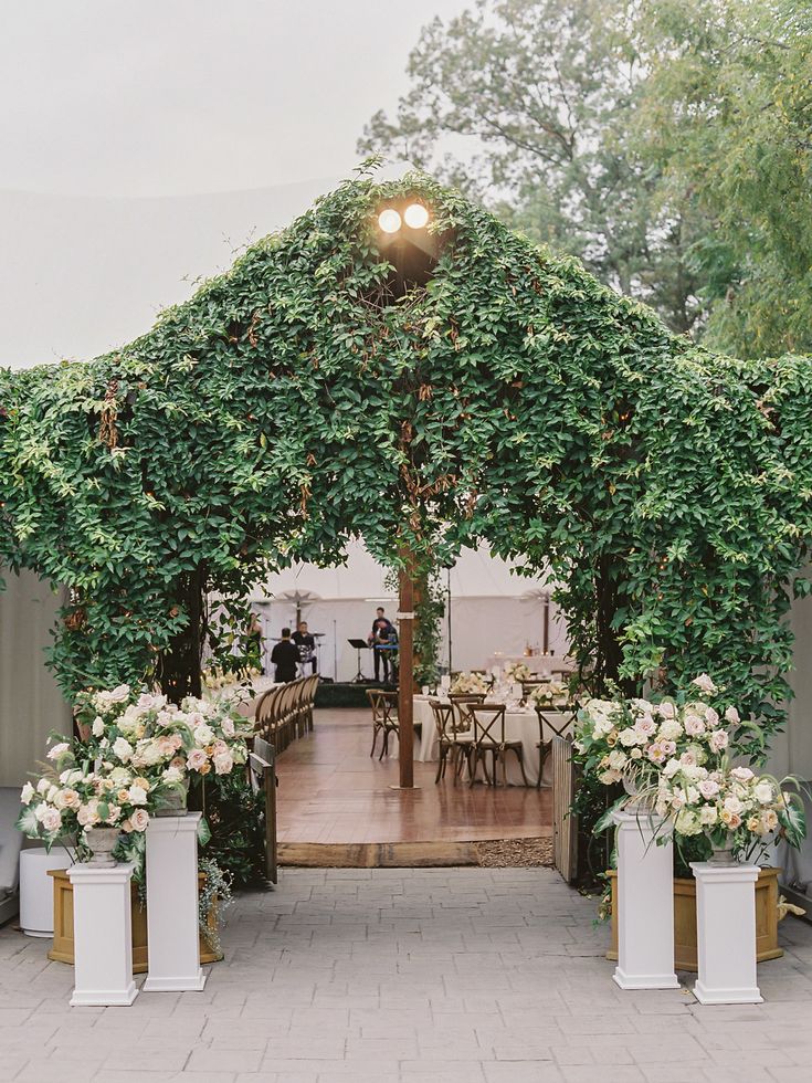 an outdoor wedding venue with white flowers and greenery on the front entrance to the ceremony