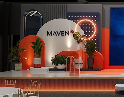 an orange and white stage set up for a show with chairs, tables and potted plants