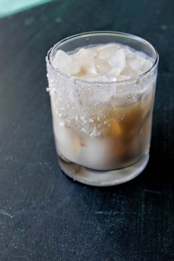 a glass filled with ice sitting on top of a table