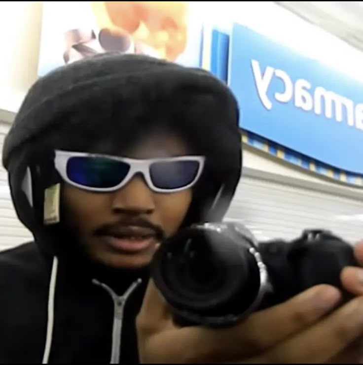 a man wearing sunglasses and holding a camera