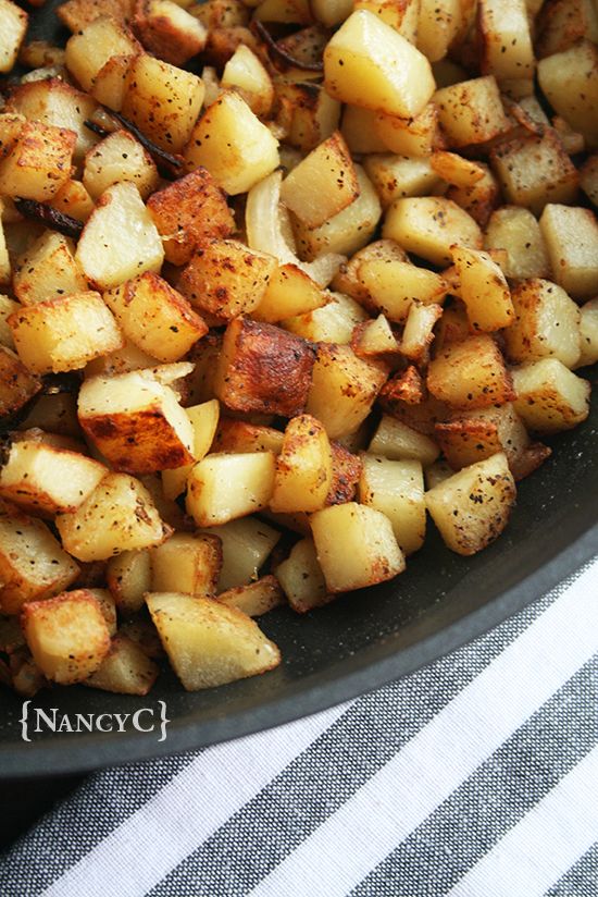 cooked potatoes in a skillet with seasoning on the side, ready to be eaten