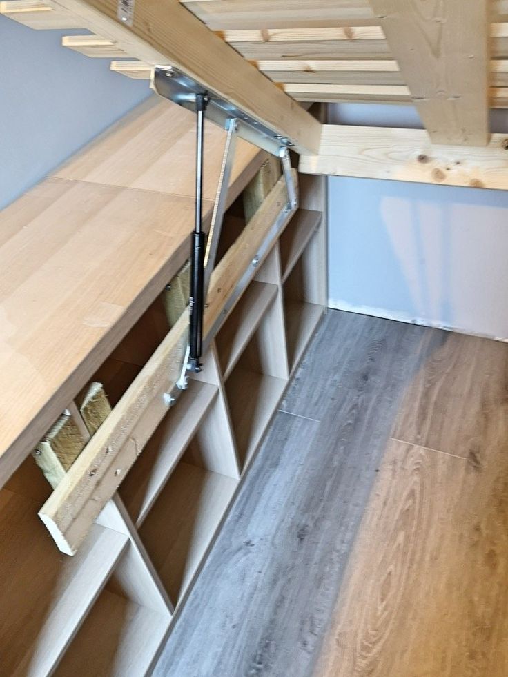 a loft bed with wooden shelves underneath it